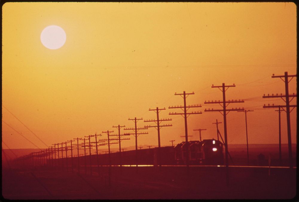 Transmission lines and railroad near Salton Sea. District of Los Angeles smog obscures the sun, May 1972. Photographer:…