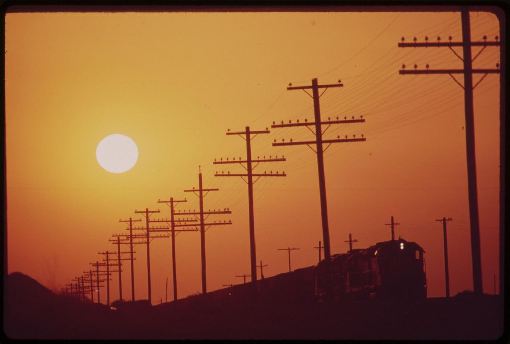 Transmission lines and railroad near Salton Sea. Smog from Los Angeles causes haze, May 1972. Photographer: O'Rear, Charles.…