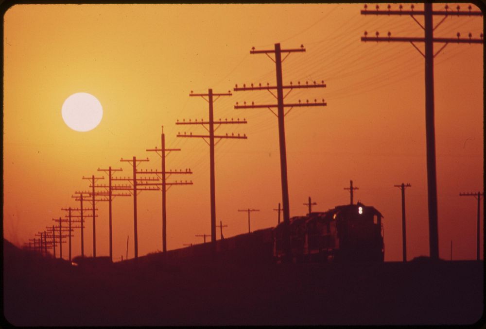 Railroad and transmission lines near Salton Sea. Hazy sun is caused by distant Los Angeles smog, May 1972. Photographer:…