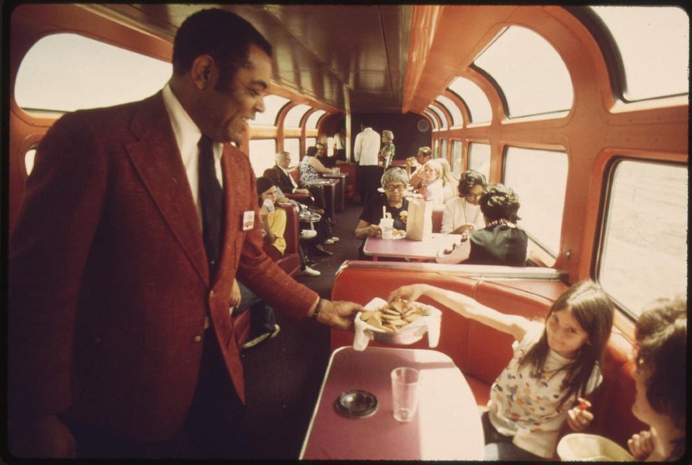 An Amtrak passenger service director serves cookies to passengers in the lounge car of the Southwest Limited enroute from…