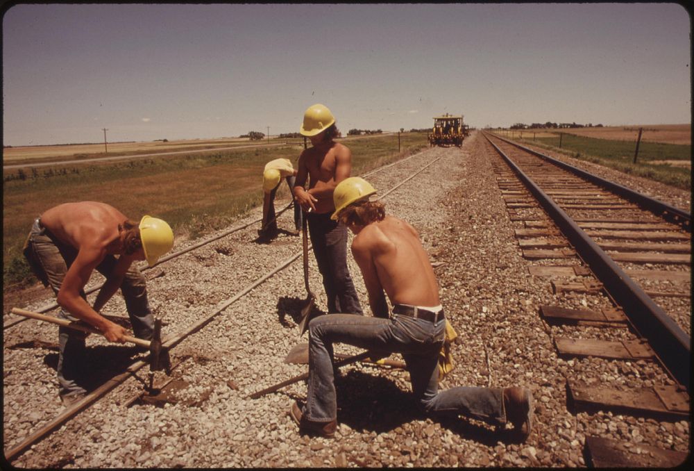 Railroad work crew improves the tracks and bed of the Atchison, Topeka and Santa Fe railroad near Bellefont, Kansas, June…