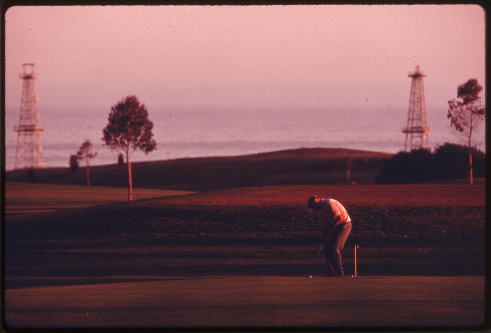 Oil derricks are located near the Sandpiper Golf Course, June 1975. Photographer: O'Rear, Charles. Original public domain…