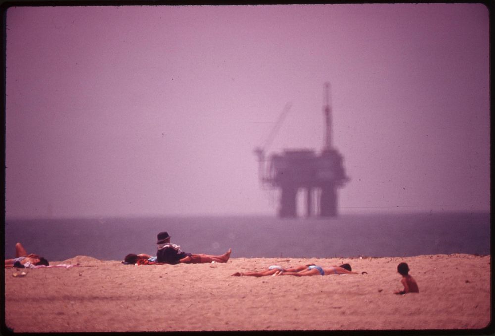 Sunbathers at Huntington Beach, and an oil platform offshore, May 1975. Photographer: O'Rear, Charles. Original public…