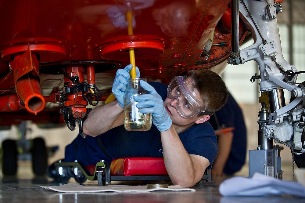 U.S. Coast Guard Airman Lucas Dellams takes fuels sample from an HH-65B Dolphin helicopter during a routine maintenance…