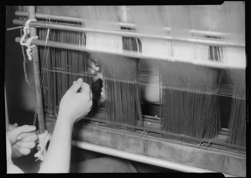 Textiles. Wishnack Silk Company. Picture of a warp being entered. Shows the enterer and hand-in at work. The warp is slung…