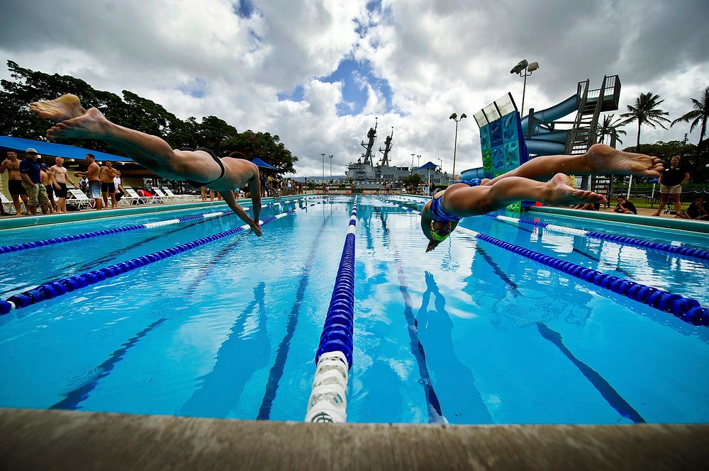 A U.S. Sailor and a New Zealand sailor compete in a Rim of the Pacific (RIMPAC) 2012 international swim meet at Scott Pool…