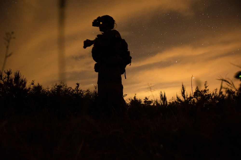 A U.S. Navy SEAL scans a field for simulated enemy threats during Operation Urban Corkscrew as part of Emerald Warrior 2013…