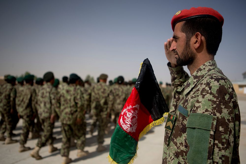 An Afghan National Army officer with the 215th Corps salutes passing troops during a ceremony commemorating the 94th…