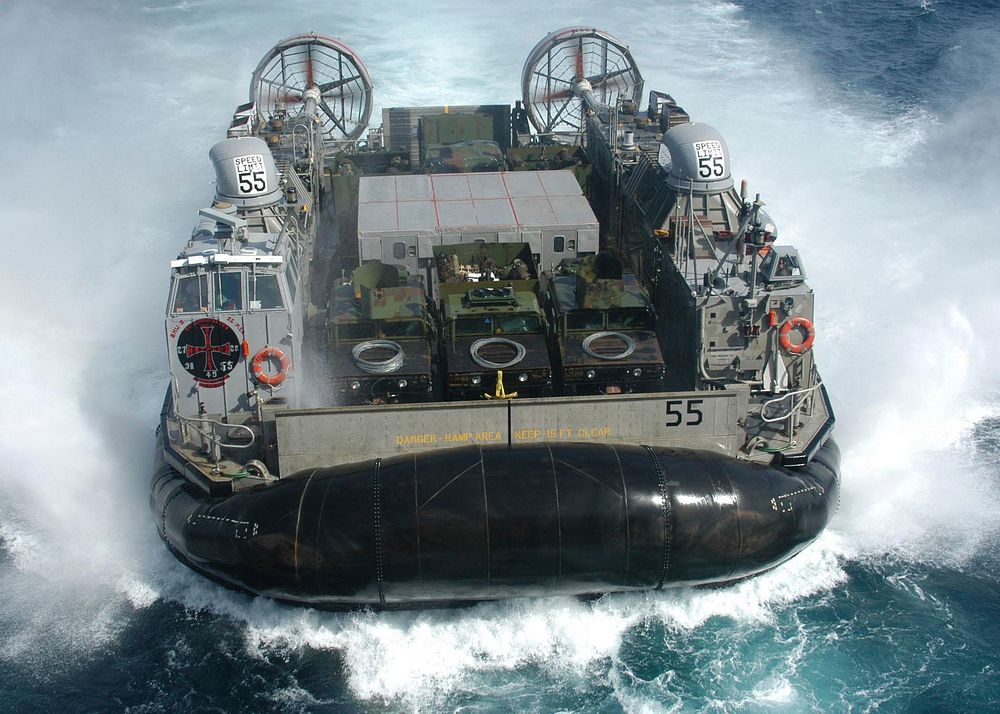 LCAC-55, a Navy Landing Craft Air Cushion (LCAC), maneuvers to enter the well deck of the amphibious assault ship USS…