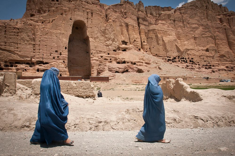 Two women walk past the huge cavity where one of the ancient Buddhas of Bamiyan, known to locals as the "Father Buddha,"…