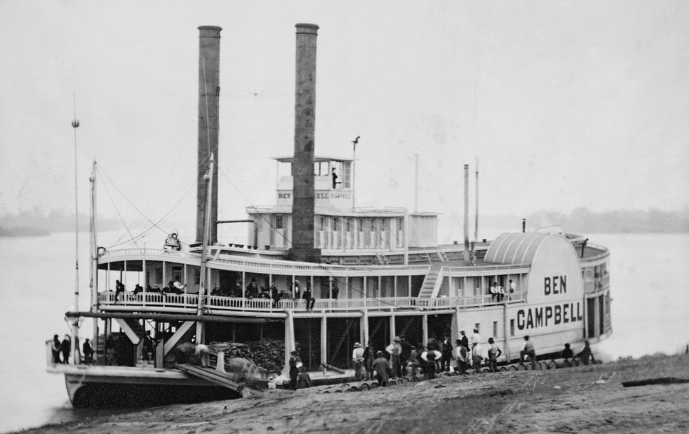 Ben Campbell steamship at landing, restored version of a daguerreotype. Cropped, with artifacts removed, mild…