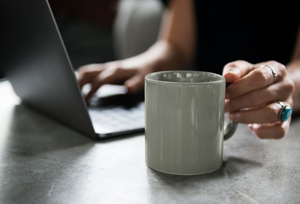 Woman grabbing gray coffee mug