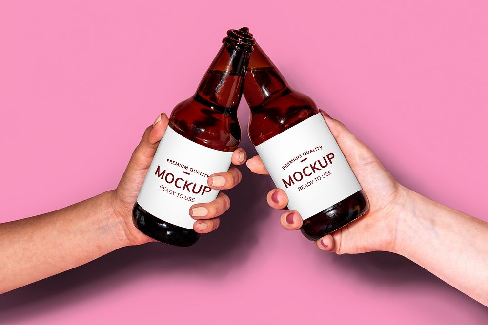 Hands holding beer bottles against a pink background mockup