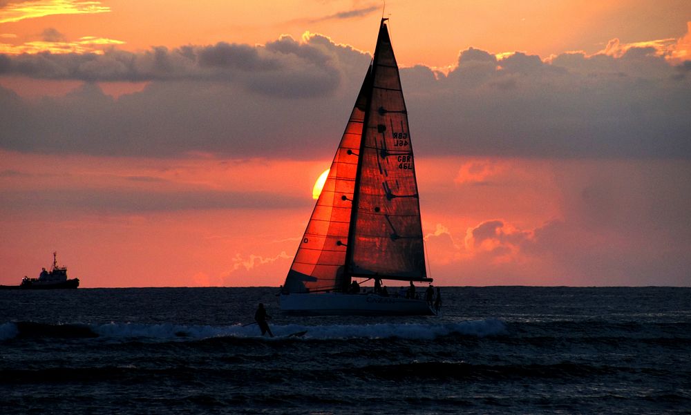 Sunset ocean scenery, sailboat, Hawaii.
