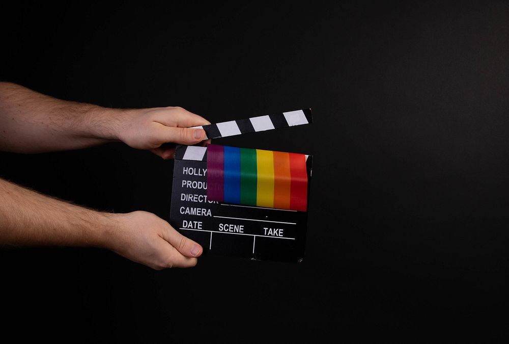 Hand holding movie clapper and rainbow flag on black background📝 I am a huge supporter of Open Knowledge and appreciate any…