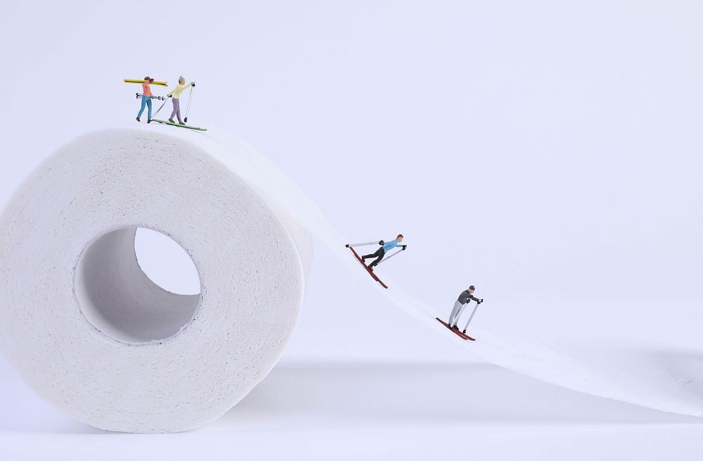 Miniature skiers skiing, toilet paper.