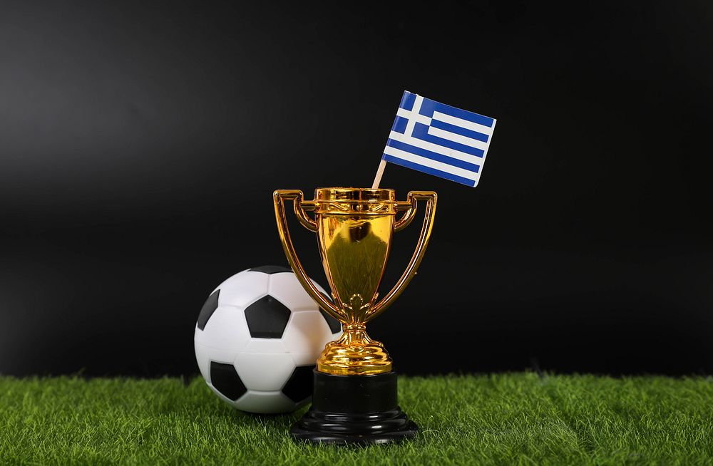 Golden trophy and football ball with flag of Greece   