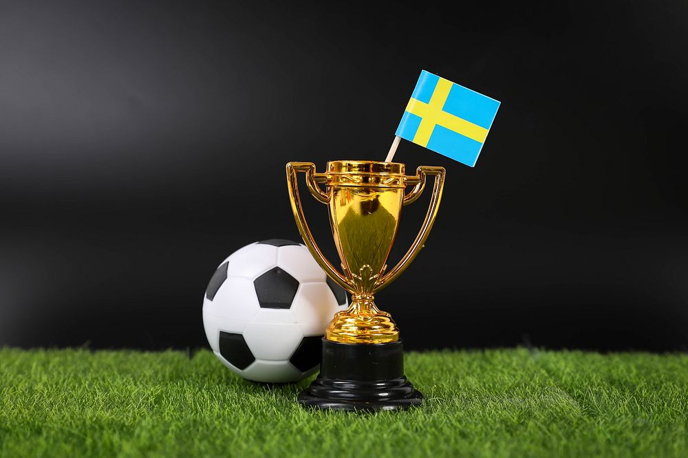 Golden trophy and football ball with flag of Sweden   