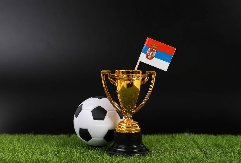 Golden trophy and football ball with flag of Serbia 