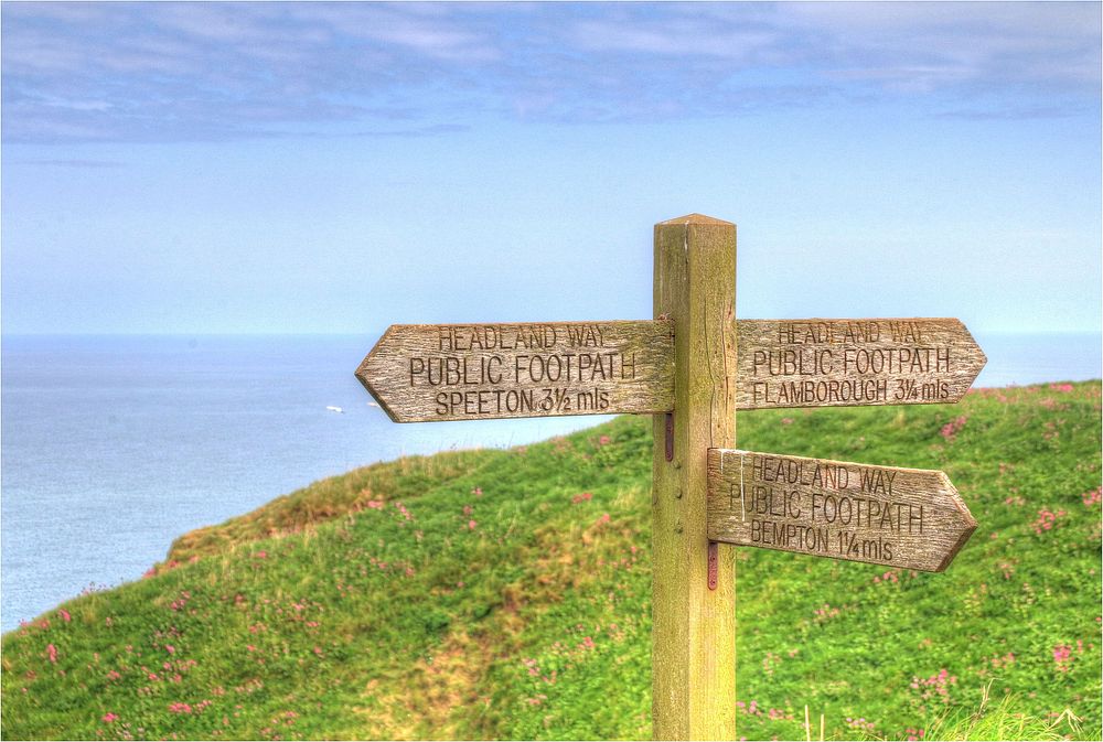 Signpost, hilltop coastline field landscape.