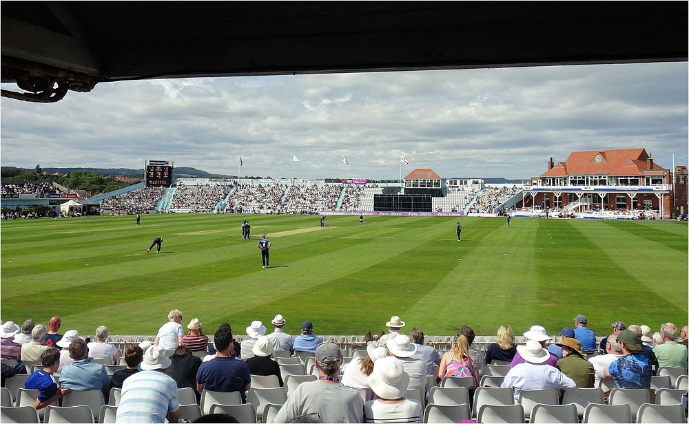 Sport stadium match, cricket game.