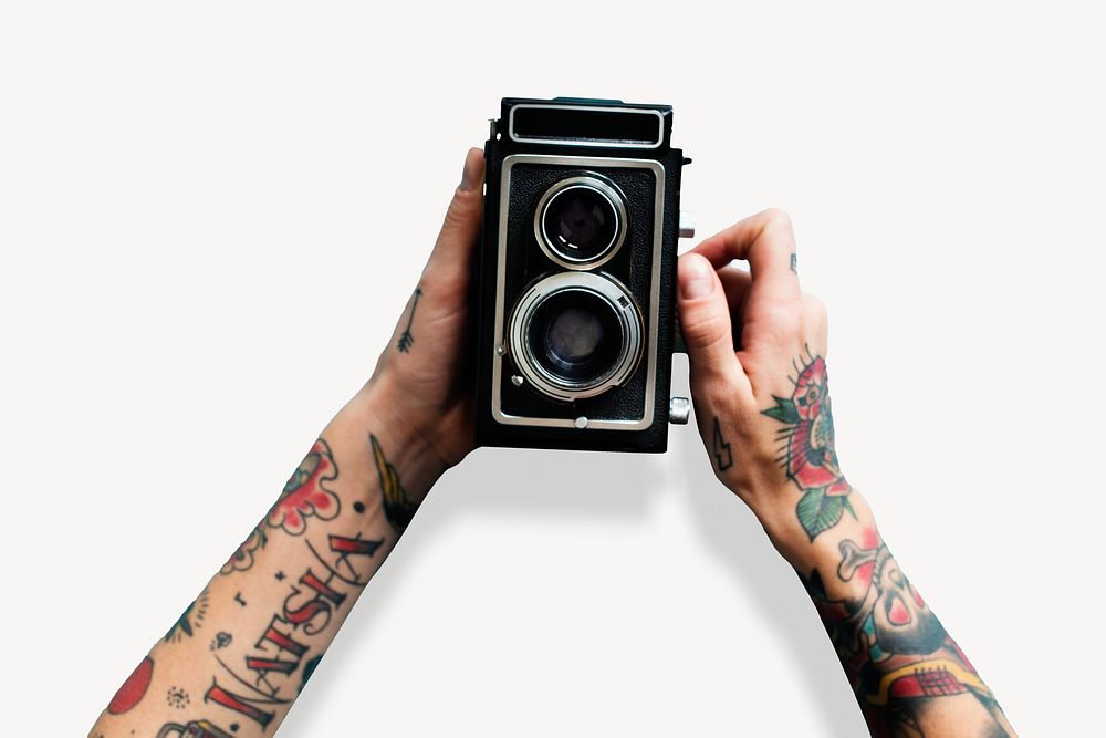 Retro film camera, held by tattooed hands