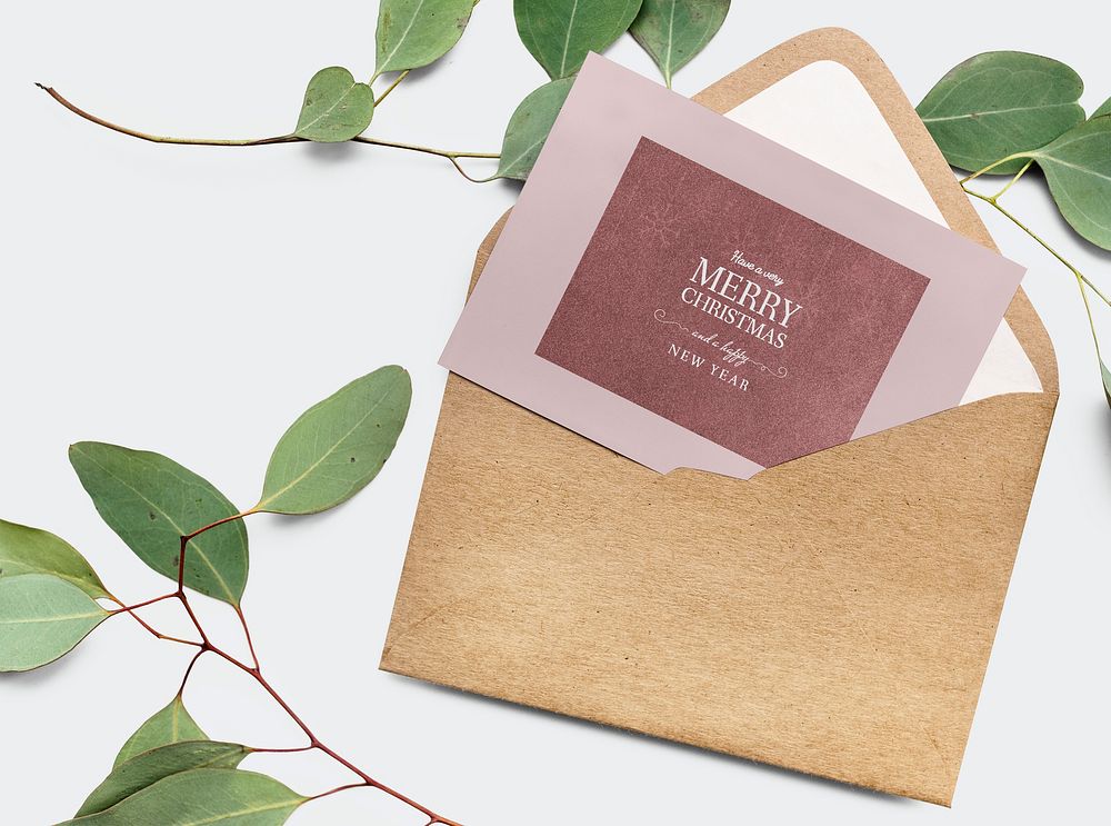Card in an envelope mockup with leaves in the background