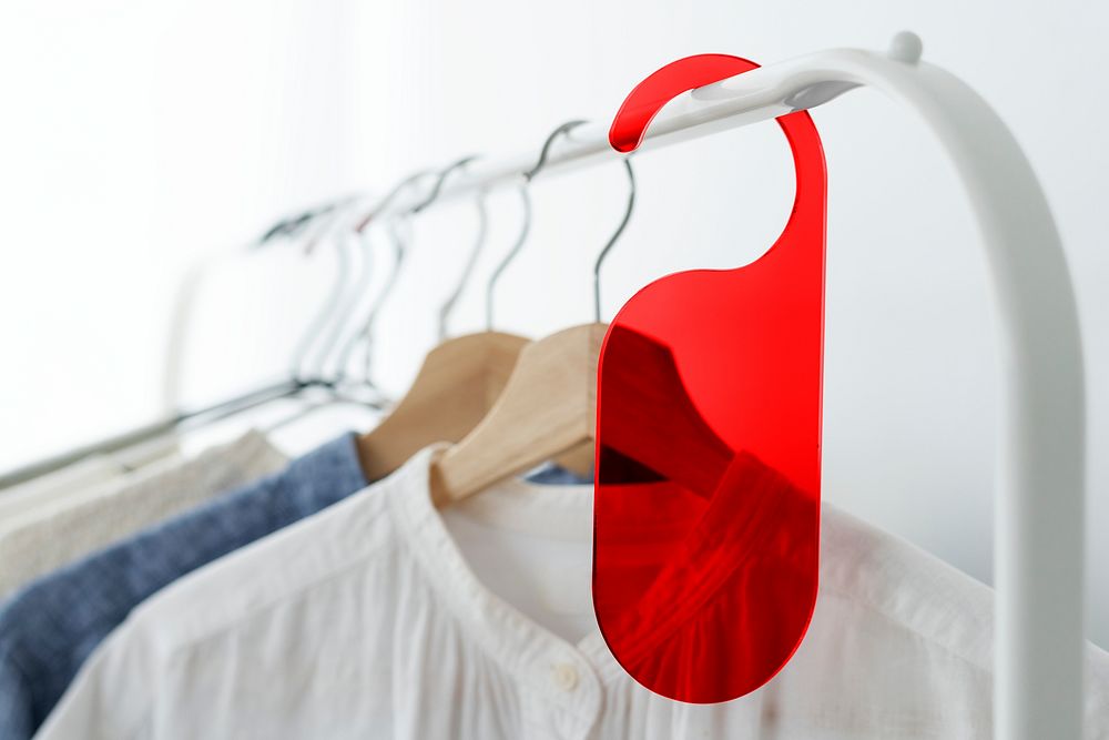 Shirt on a clothing rack with a red tag mockup in a studio