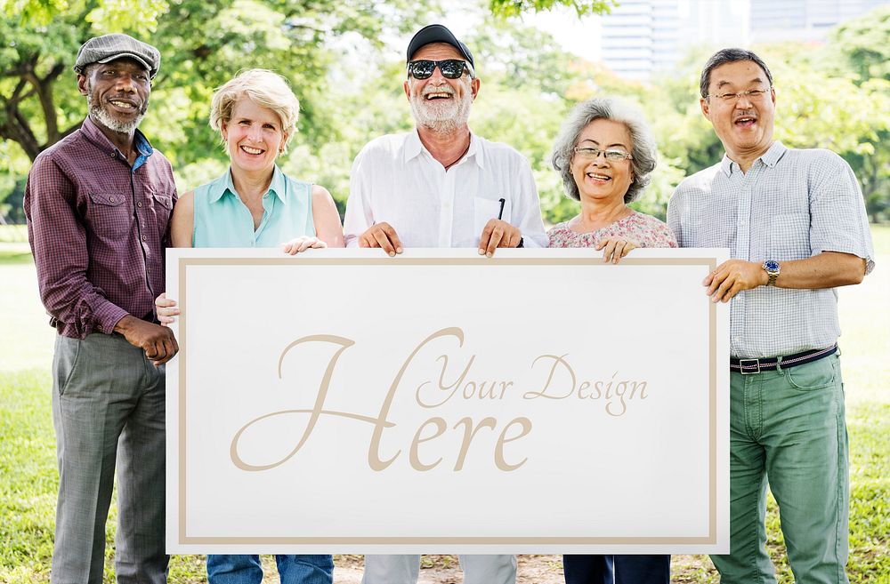 Group of diverse seniors showing a poster mockup in a garden