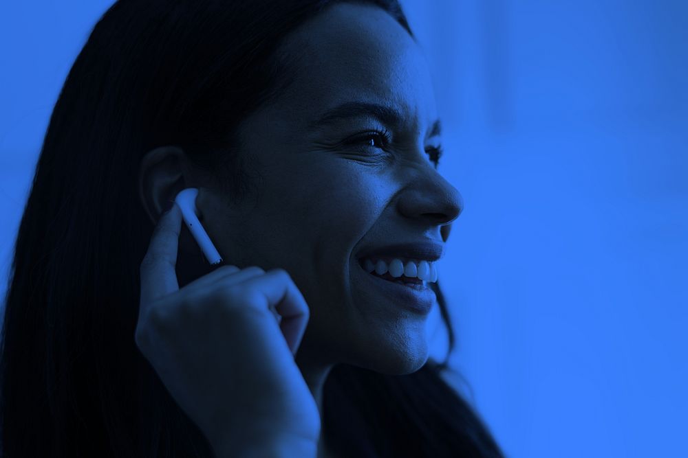 Happy woman using wireless earphones