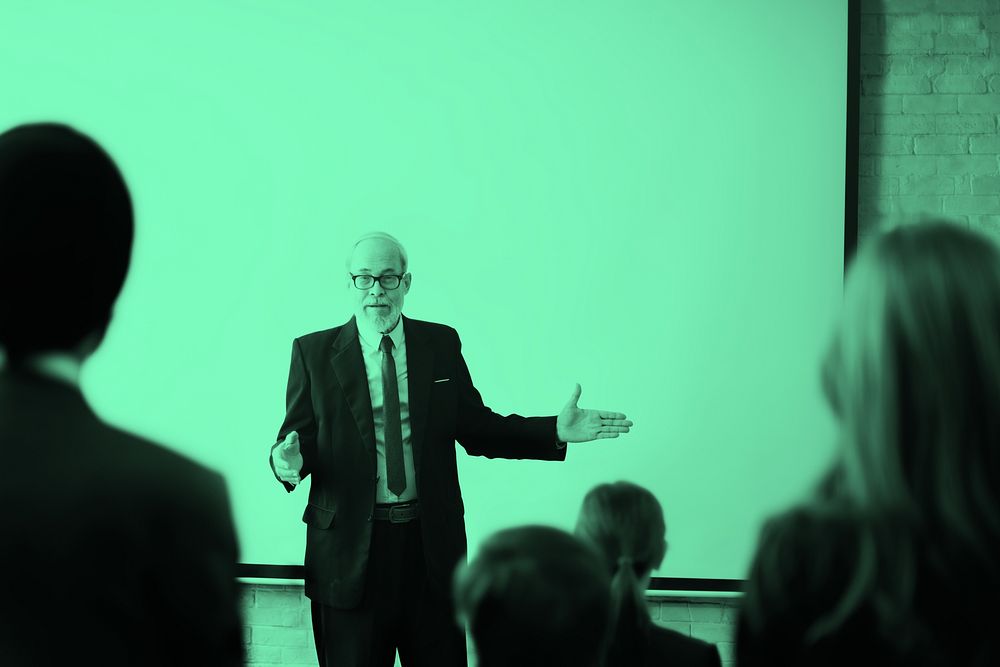 Senior businessman talking in a meeting room, green tone