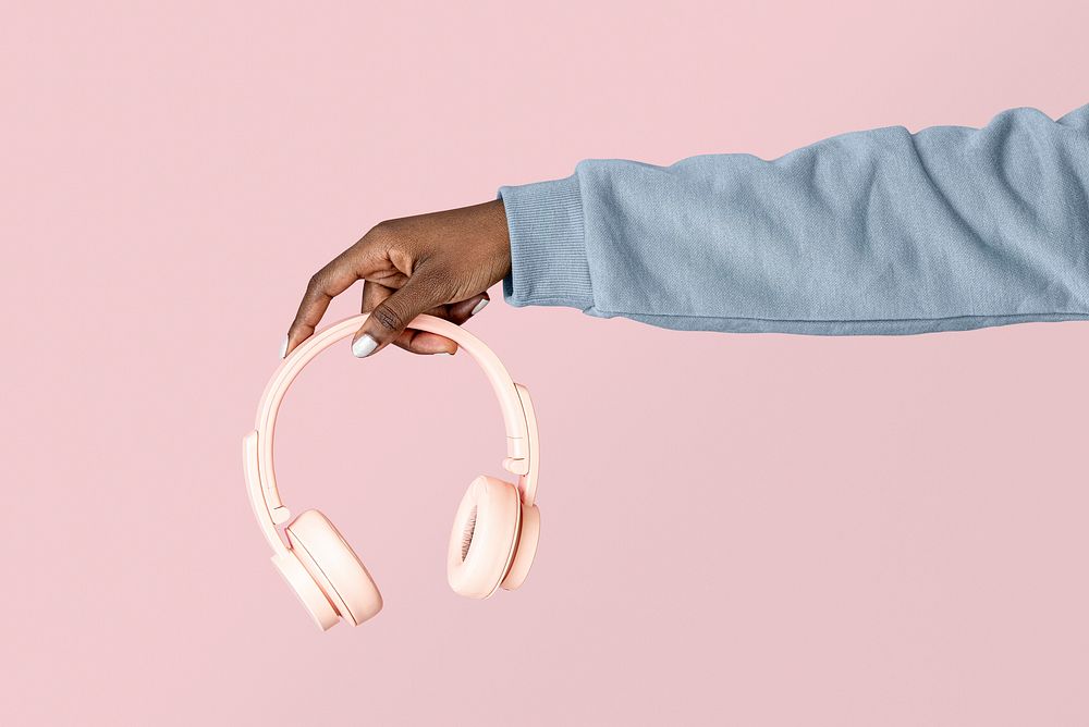 Hand holding pink headphones