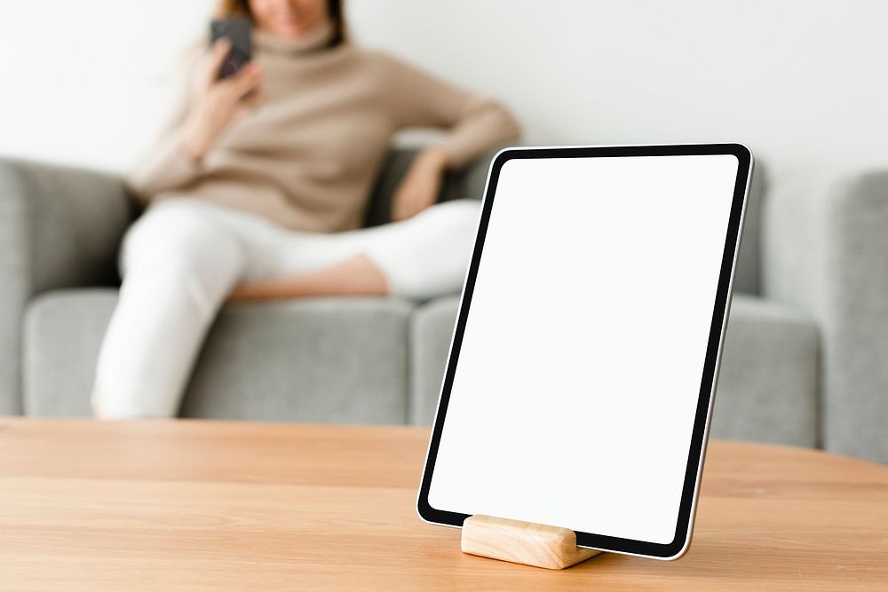 Digital tablet white screen mockup psd on a wooden table