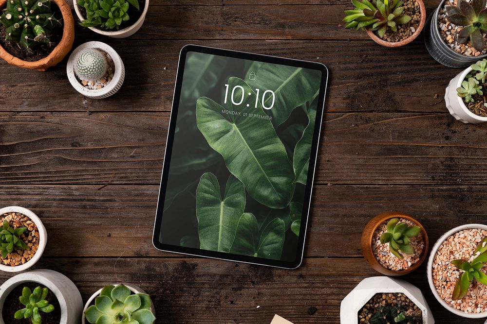 Tablet screen mockup psd on plant parent table flat lay