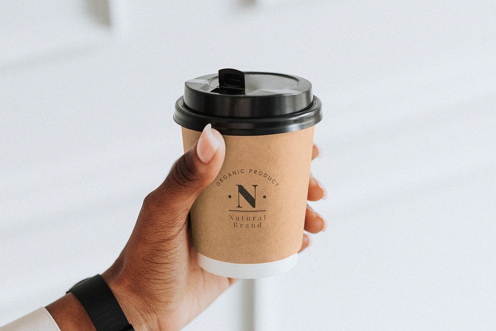 Hand holding a coffee cup mockup