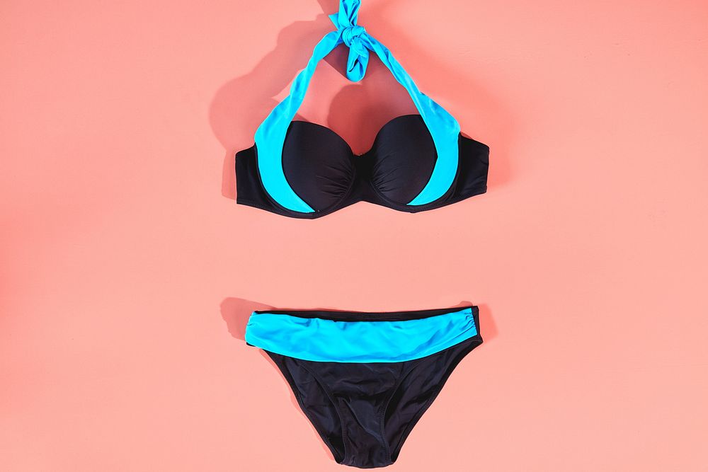 Blue and Black two piece bathing suit on a pink background