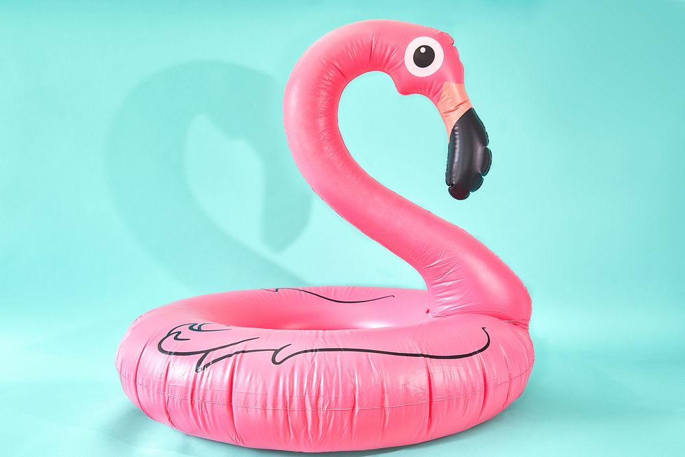 Inflatable flamingo pool toy on a teal background.