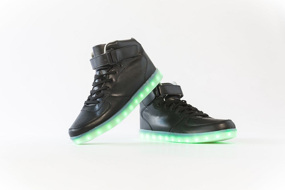 Black light up shoes, showing insides of shoes with one heel resting on the top of the other shoe.