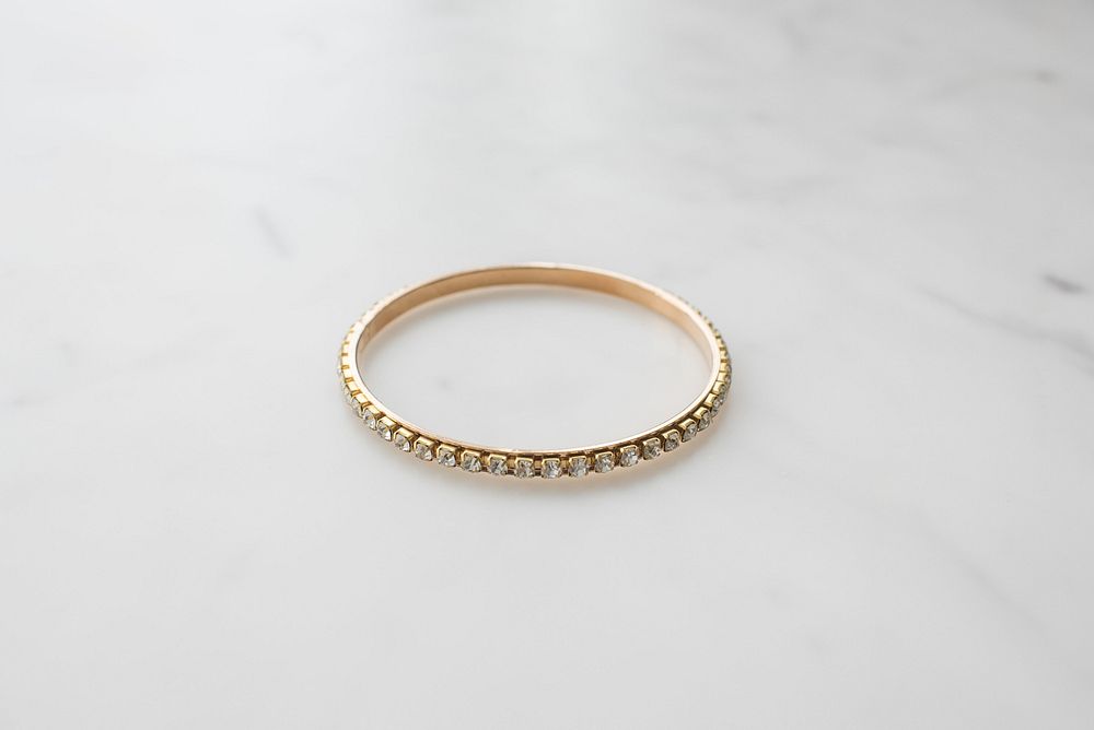 Gold bangle bracelet with studded jewels all the way around.