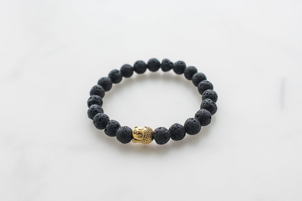 Black stone looking beads with gold buddha charm bracelet.