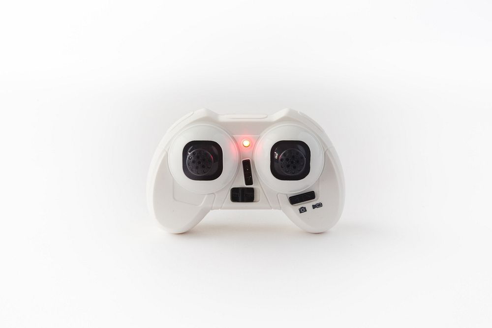 White and black drone controller with red light.