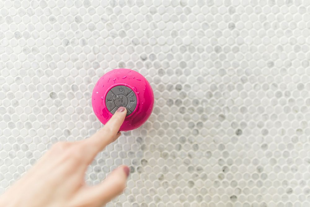 Pink waterproof speaker on wall.