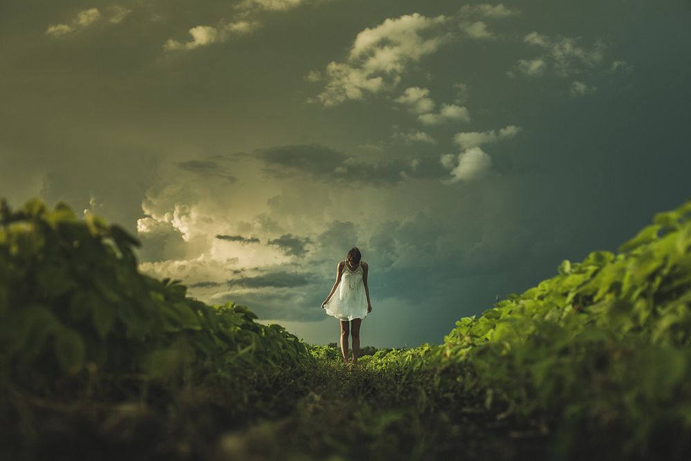Woman in nature, stormy sky.