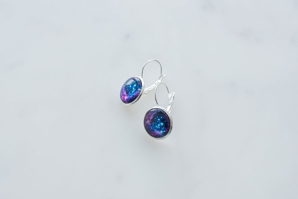 One set of galaxy earrings with silver hardware.