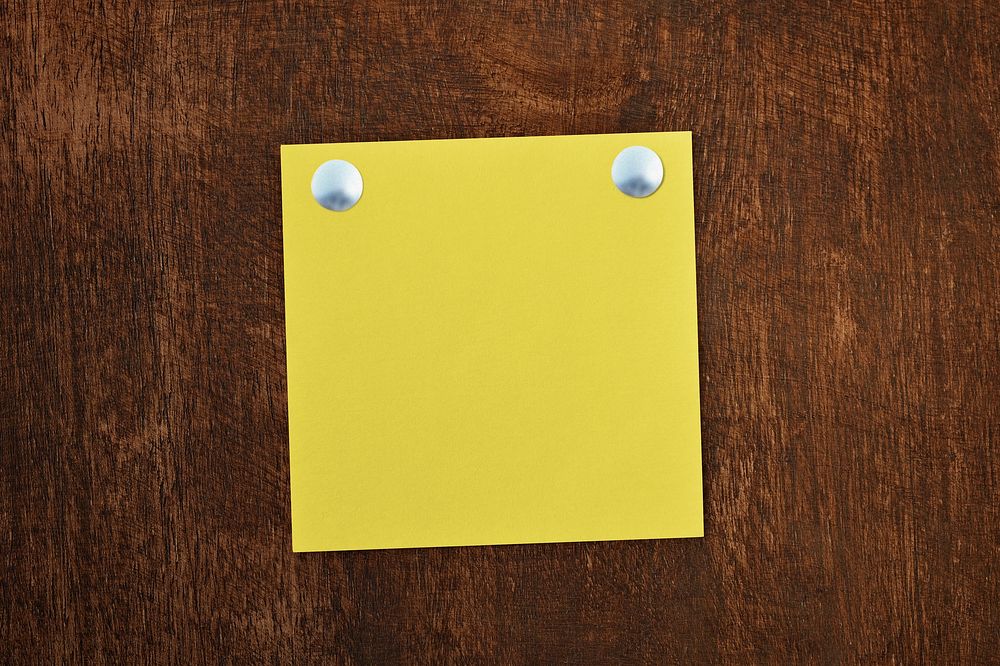 Yellow sticky note with push pin