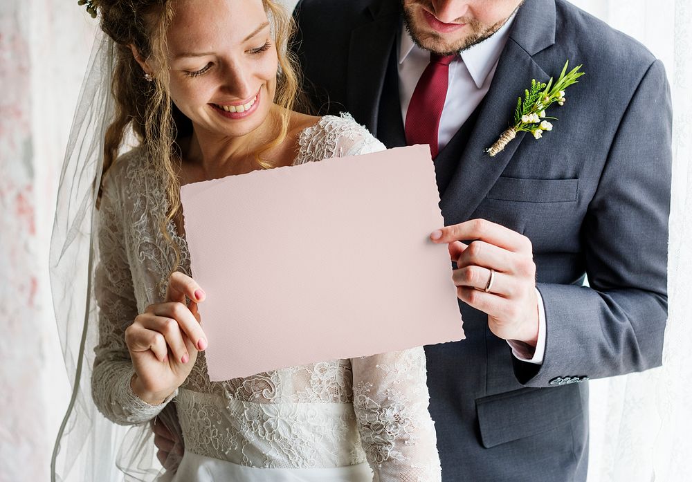 Bride and the groom holding an empty placard