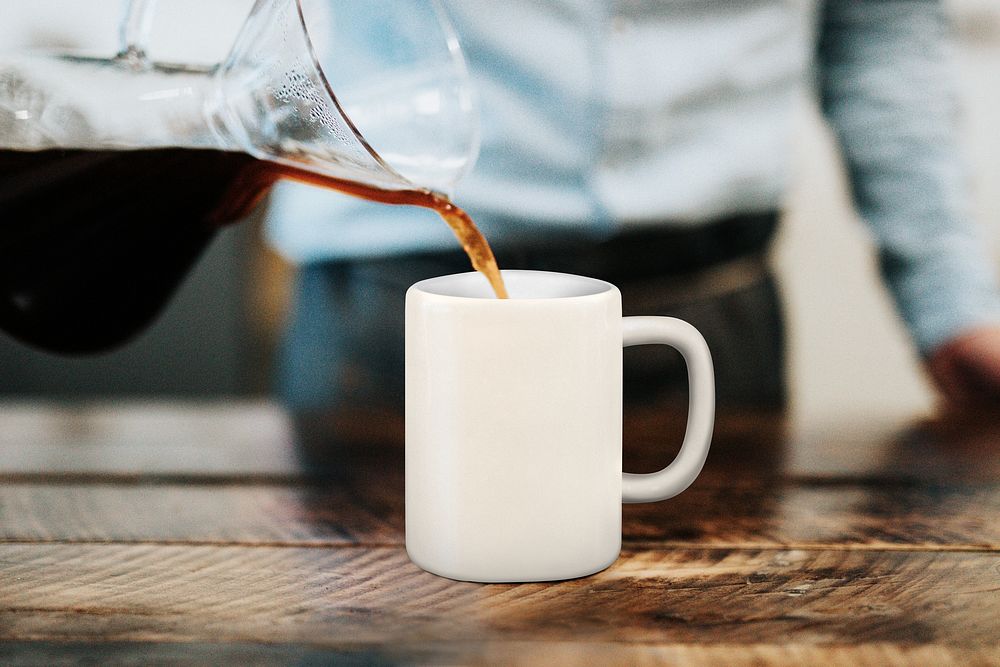 Barista pouring coffee into mug