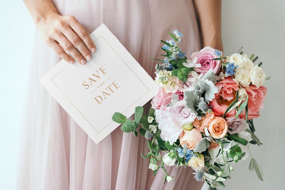 Bride holding a save the date card mockup with a bouquet of flowers