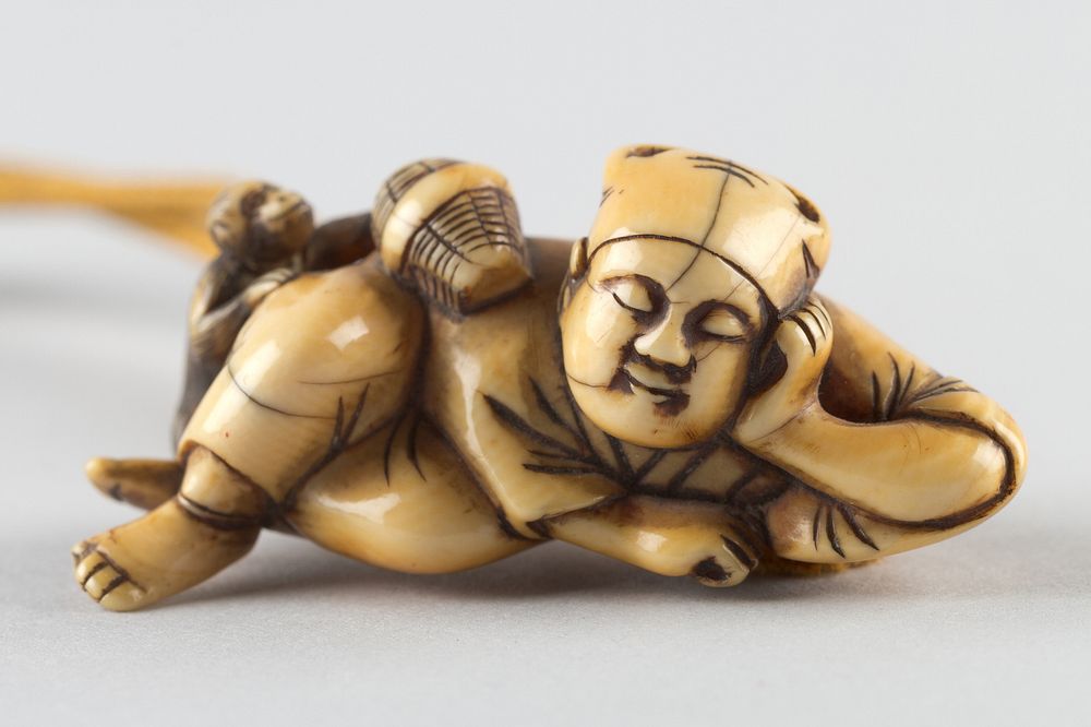 Netsuke of a Man Sleeping while Monkey Steals Contents of Basket