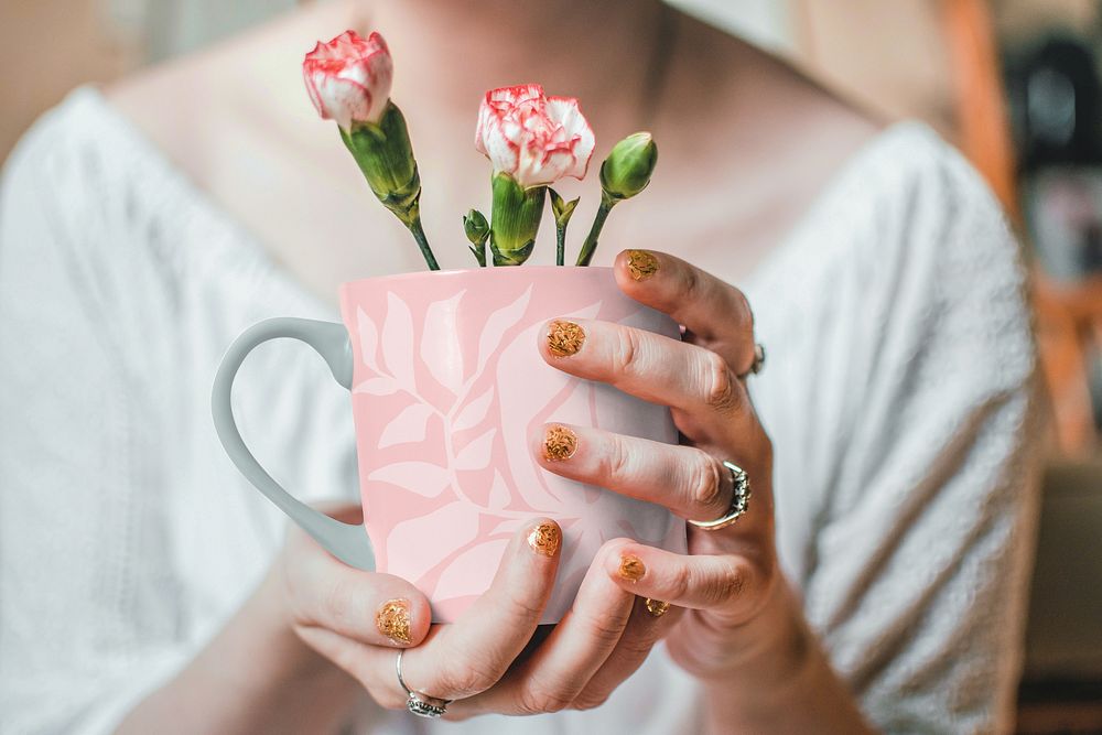 Woman holding pink flower mug